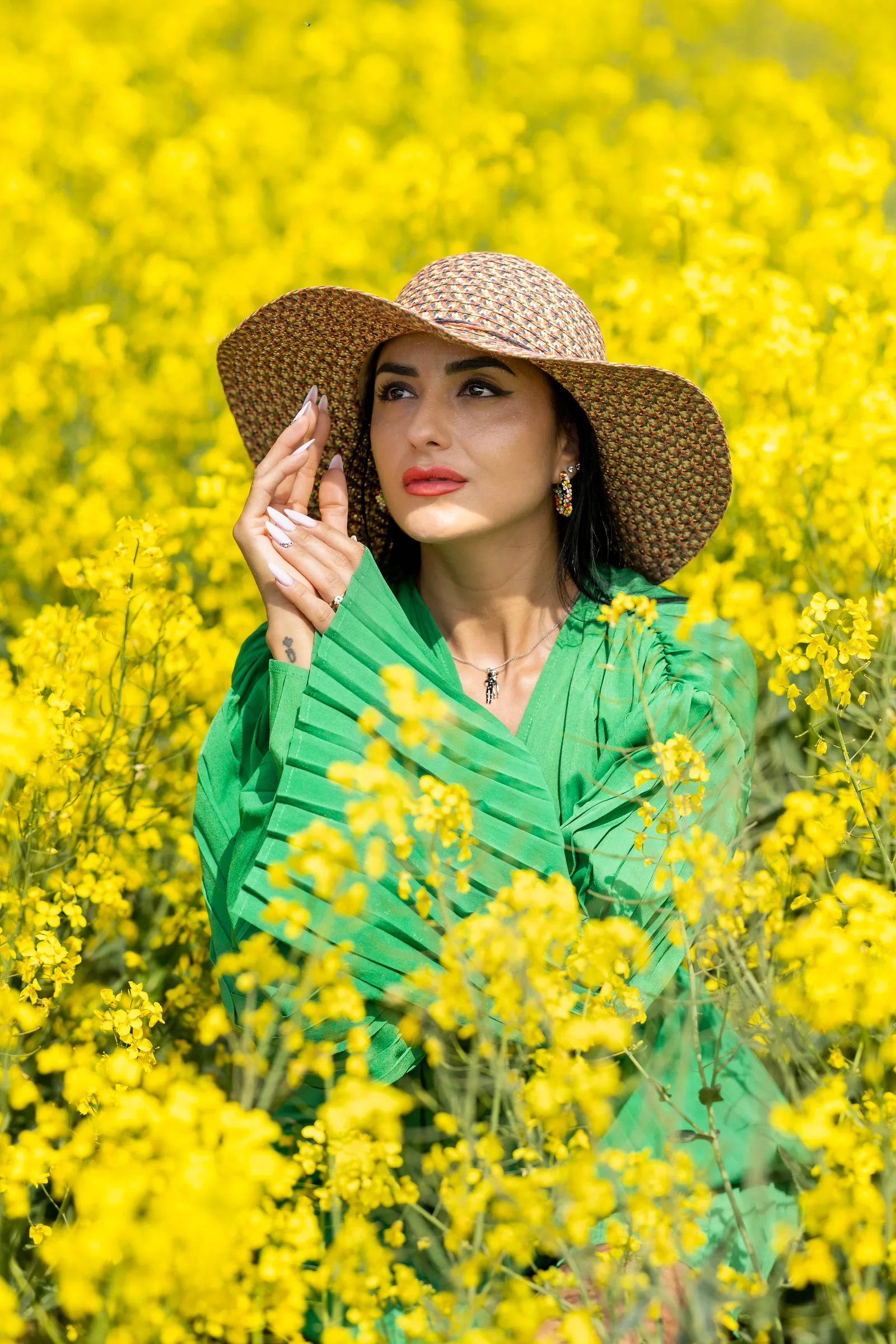 Woman in leopard print hat posing in a yellow flower field