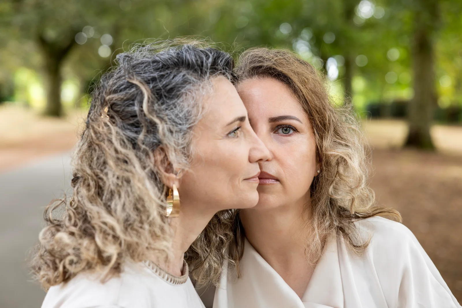 Color portrait of two women in profile, faces close together, one with gray curls