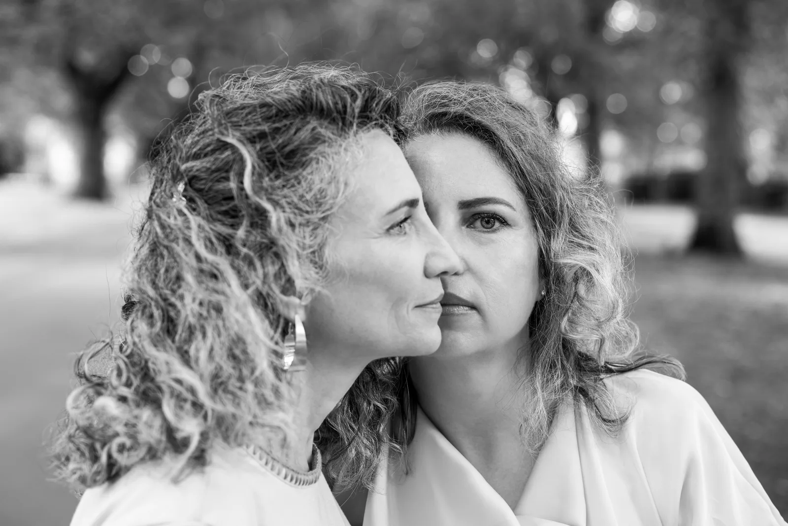 Black and white portrait of two women in profile, faces close together
